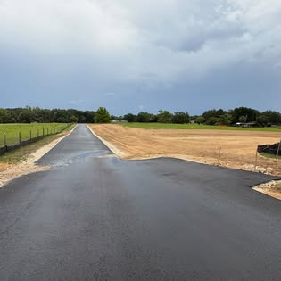 Newly paved road with graded shoulders on cleared land
