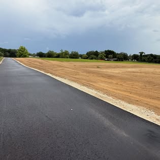 Fresh asphalt alongside graded dirt